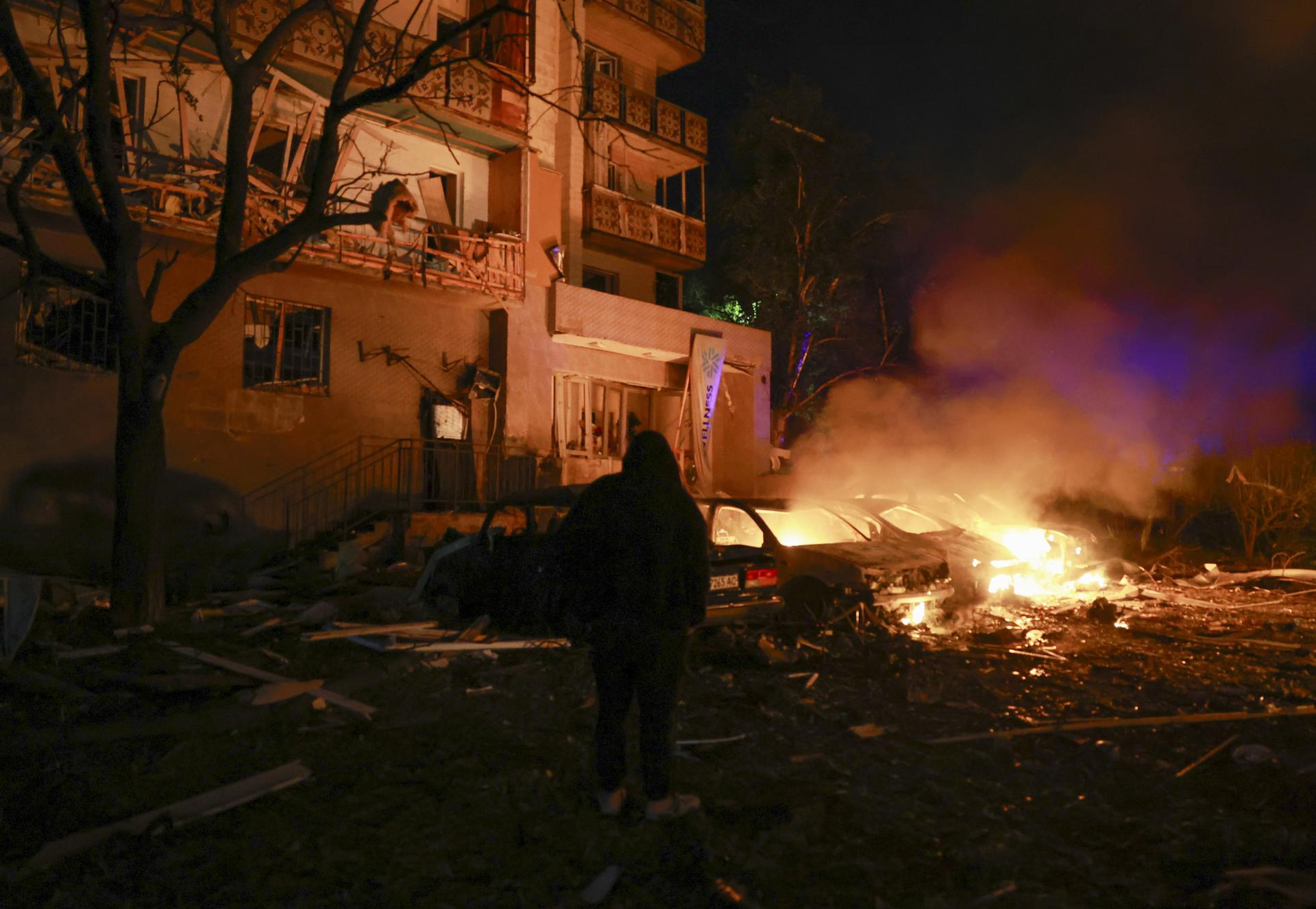 Rescatistas ucranianos trabajan en el lugar de un ataque con misiles rusos contra una zona residencial de Kiev